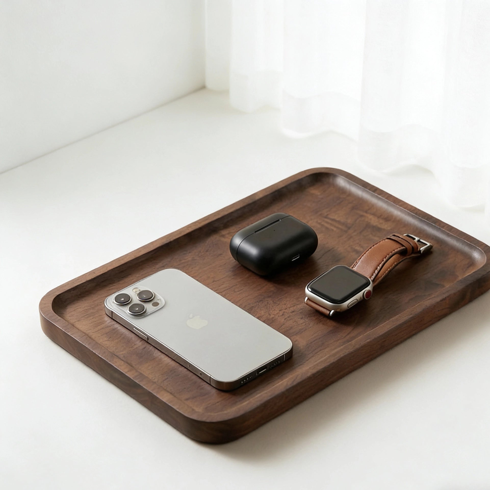 Walnut catchall tray holding phone, keys and watch on a clean surface, ideal entryway or desk organizer.