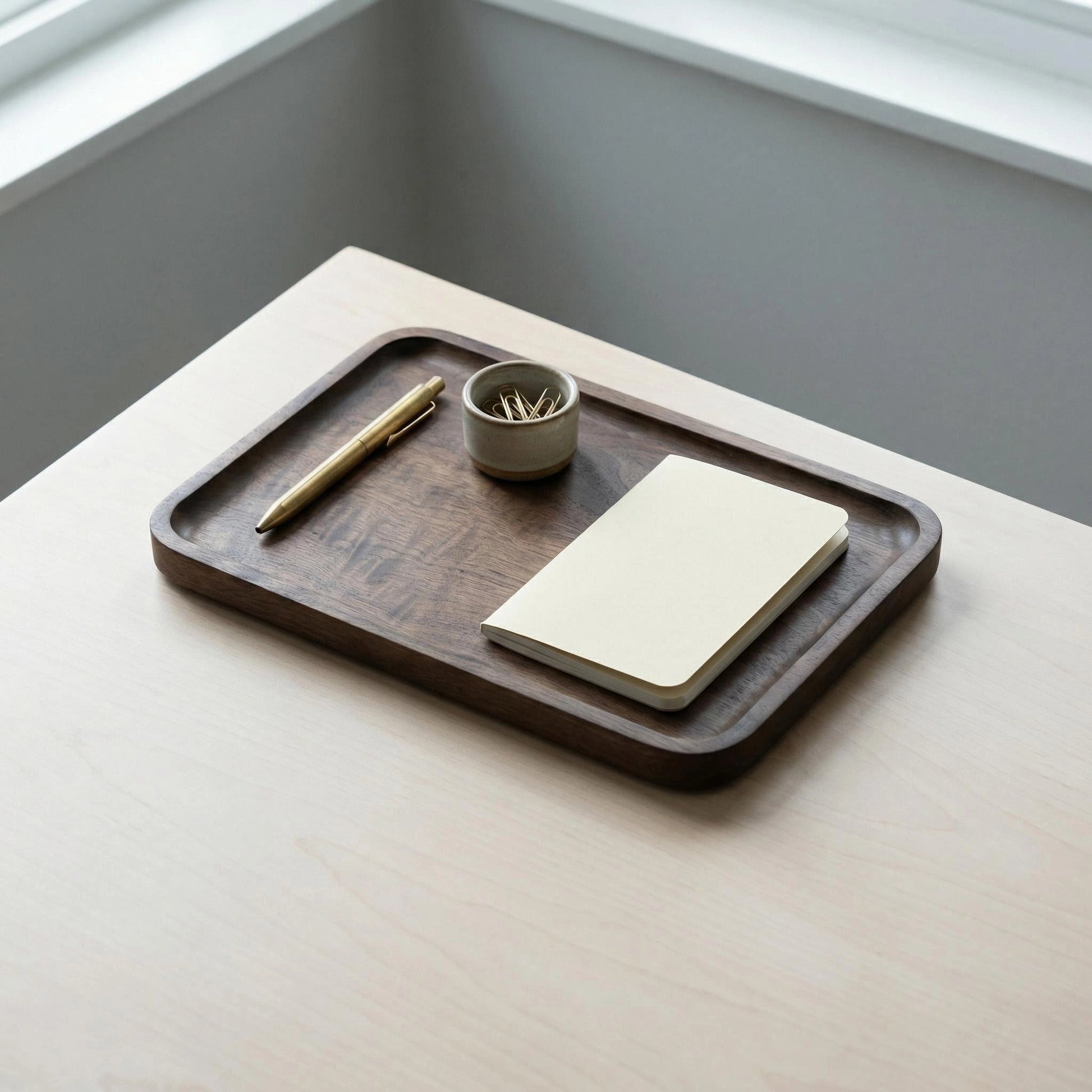Walnut catchall tray holding small items like rings and keys, clean minimalist styling.